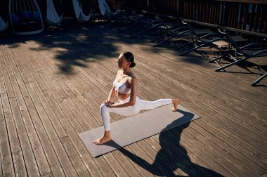 Esnek vücut tipi ve egzersizleri. Spor elbiseli genç bayan dışarıda..