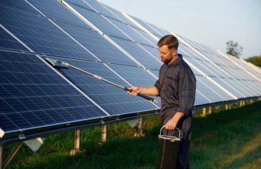 Adam gündüz vakti güneş panelleriyle çalışıyor..