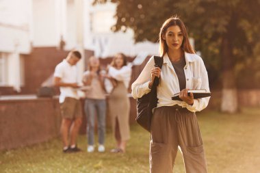 Poz vermek, ayakta durmak. Bir grup öğrenci birlikte dışarı çıktılar..