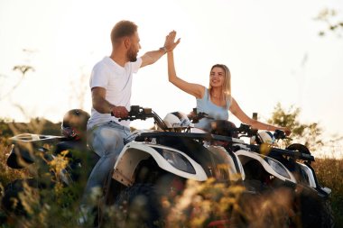 Çak bir beşlik hareketi. Erkek ve kadın dışarıda ATV 'deler..