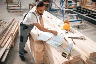 Bir sürü kağıt ve plan. Ahşap depoda sanayi işçisi..