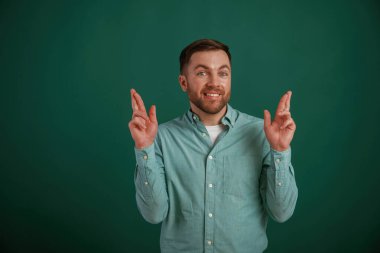 Daha iyisini umarak dua et. Adam stüdyoda arka planda duruyor..