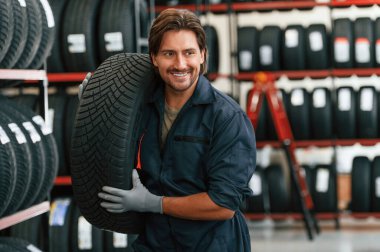 Neşeli, gülümseyen. Lastik tamir servisinde adam var..