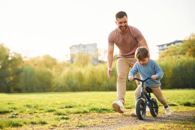 Bisiklet, eğlenmek. Mutlu baba ve oğlu yazın sahada olurlar..