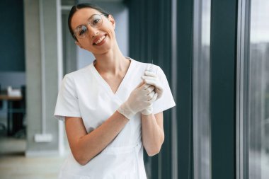 Şırınga ellerinde. Beyaz önlüklü kadın doktor içeride..