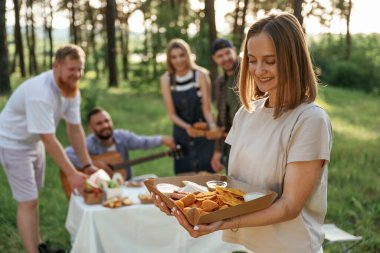 Lezzetli yemekler ellerde. Bir grup arkadaş, ekolojik kutularda yiyeceklerle sahada piknik yapıyorlar..