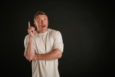 Yeni ürün, kopyalama alanında gösteriliyor. Adam stüdyoda arka plana karşı..