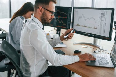 Bir projeye odaklanmış. İki çalışan ofiste birlikte çalışıyor..