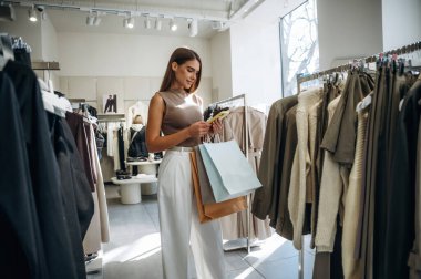 Sadece kaliteli ürünler. Kadın mağazadan kıyafet seçiyor..