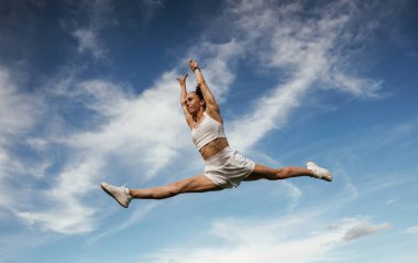 Arka planda güzel bir gökyüzü. Genç sıska kadın dışarıda..