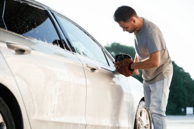 Nakliye aracı temizleniyor. Çamaşır servisi. Adam dışarıda arabasıyla bekliyor..