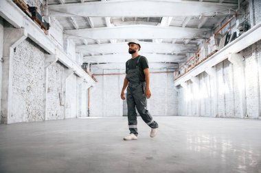 Beyaza boyanmış. Erkek işçi boş depoda..