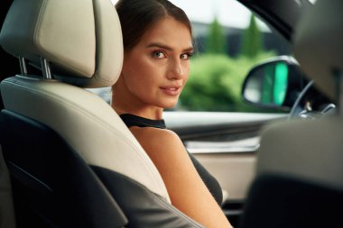 Geriye bakıyorum. Kadın arabada oturuyor..