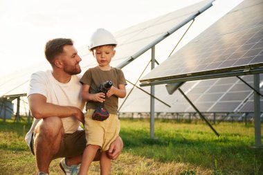Baba ve küçük oğlu güneş panellerinin yakınındalar..