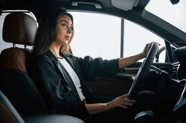 Yandan bak. Güzel iş kadını yeni arabasında..