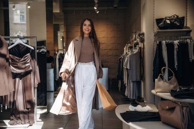 Mutlu yüz ifadesi. Kadın mağazadan kıyafet seçiyor..