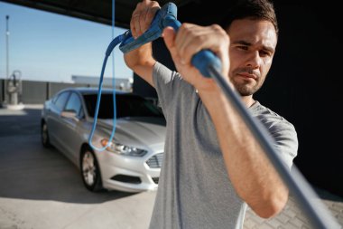 Otomobili yıkamaya hazırım. Adam dışarıda arabasıyla bekliyor..