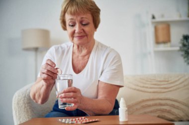 Kendi kendini tedavi et. İlaç alıyorum. Yaşlı yaşlı kadın evde, oturma odasında..