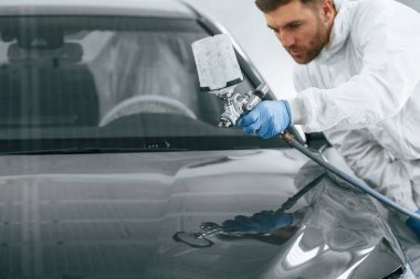 Adam sprey adam kullanarak araba boyuyor..