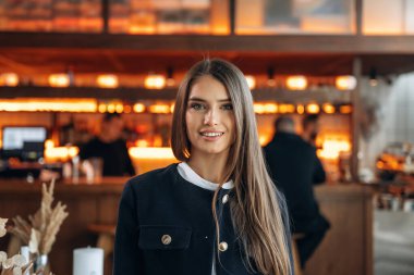 Arka planda insanlar var. Restoran sahibi ya da müdürü içeride bekliyor..