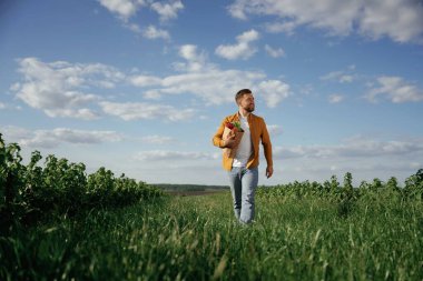 Elinde ürünler olan bir alışveriş çantası. Yakışıklı adam gün içinde tarım alanında olur..