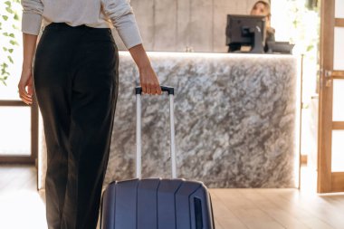 Varış, bavulla. Kadın modern otelin resepsiyonunda..