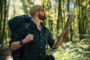 Haritayı kullanarak. Sakallı adam gündüz vakti ormandadır..