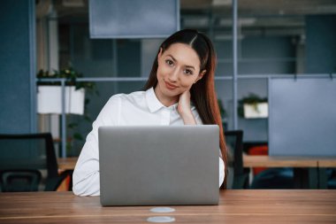 Dizüstü bilgisayarla çalışıyor. İş kadını ofisin içinde..