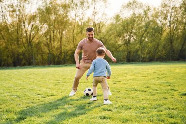 Futbol oynuyordum. Mutlu baba ve oğul yazın sahada eğleniyorlar..