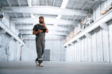 İş görüşmesi, konuşma. Erkek işçi boş depoda..