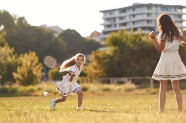 Badminton oyunu. Mutlu çocuklar yaz tarlasında.