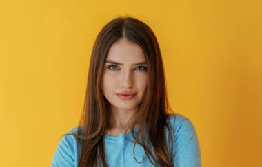 Kendine güven, portre. Genç bayan sarı arka plana karşı..