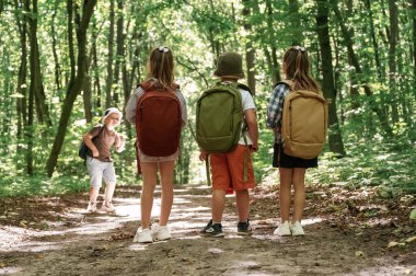 Keşfe çıkmak için uzun bir yol. Çocuklar yazın gündüz vakti ormanda..