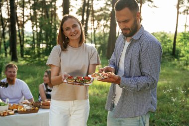 Lezzetli yemekler ellerde. Bir grup arkadaş, ekolojik kutularda yiyeceklerle sahada piknik yapıyorlar..