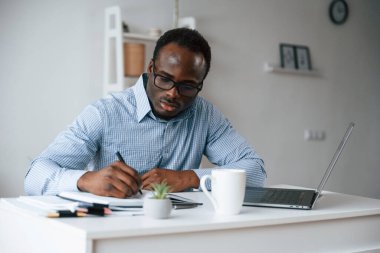 Evrak işleriyle uğraşıyorum. İşadamı laptopla ofiste..