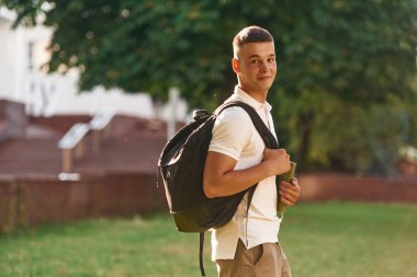 Sırt çantasıyla. Genç erkek öğrenci dışarıda..
