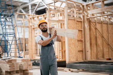 Yürüyorum, kalas tutuyorum. Ahşap depoda sanayi işçisi..