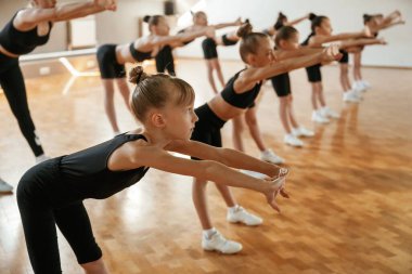 Yan görüş. Bir grup bayan çocuk içeride spor egzersizleri yapıyor..