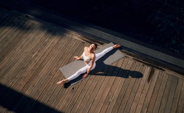 Yukarıdan bak, alıştırma yap. Spor elbiseli genç bayan dışarıda..