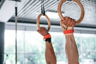 Atletizm yüzükleri kullanan güçlü bir adama yakından bakın..