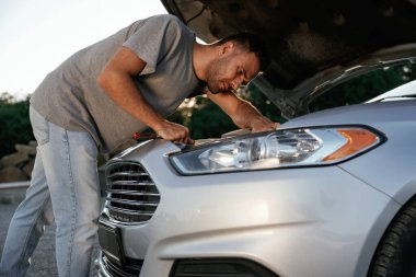 Bozuldu, kaput açıldı, tamir ediliyor. Adam dışarıda arabasıyla bekliyor..