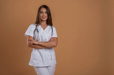 Güzel hemşire steteskopla birlikte. Genç ve güzel bir bayan stüdyoda arka plana karşı..