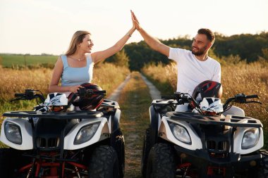 Çak bir beşlik hareketi. Erkek ve kadın dışarıda ATV 'deler..