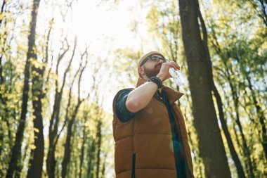 Su içiyorum. Sakallı adam gündüz vakti ormandadır..