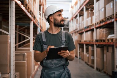 Not defteriyle kalite kontrol. Foreman depoda, kargo dağıtım işinde..