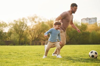 Nasıl futbol oynanacağını öğretiyorum. Mutlu baba ve oğul yazın sahada eğleniyorlar..
