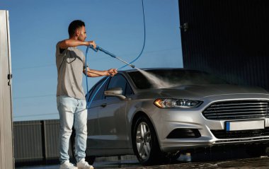 Araba yıkama servisi, adam dışarıda arabasıyla bekliyor..