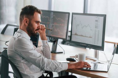 Laptop kullanıyorum. İşadamı bilgisayar başında oturuyor ve ofiste çalışıyor..