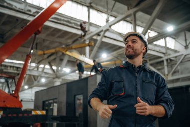 Süreci kontrol etmek, el hareketleri, iletişim. Erkek işçi, modern depo veya imalat şirketinde çalışıyor..