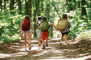 Arkadan bak. Çocuklar yazın gündüz vakti ormanda..